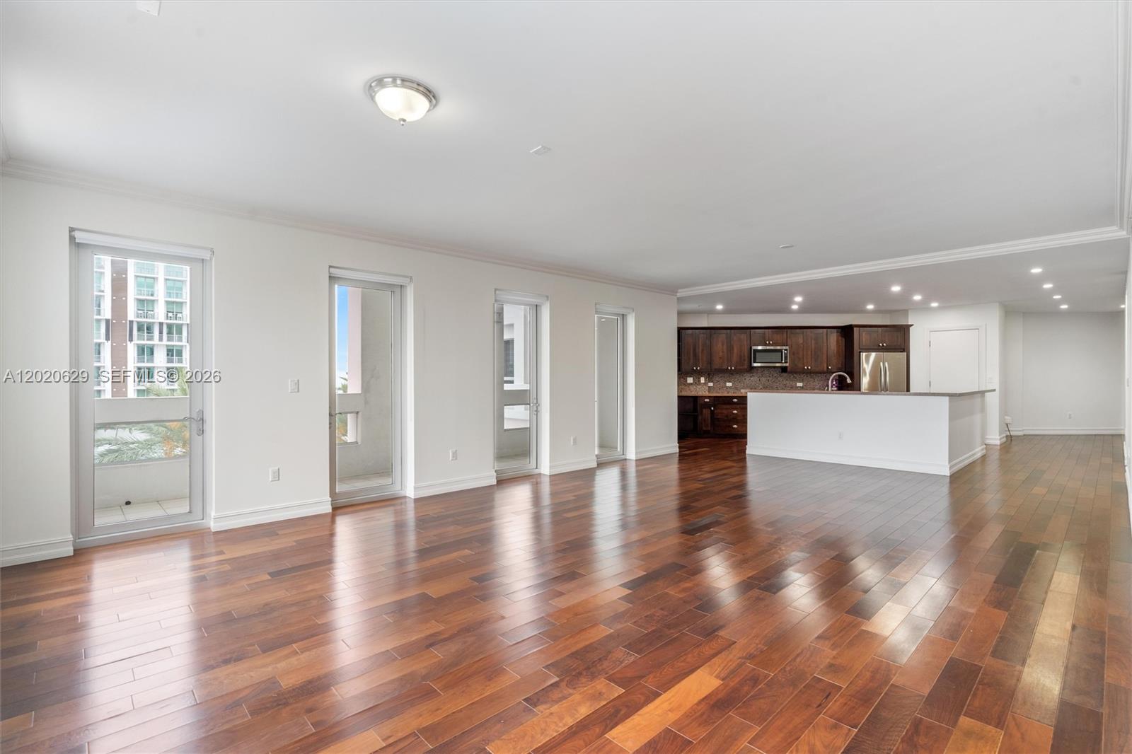 455 East Palmetto Park Road, Unit 4 Boca Raton, FL 33432 - Photo 5 of 30 a view of empty room with wooden floor and kitchen