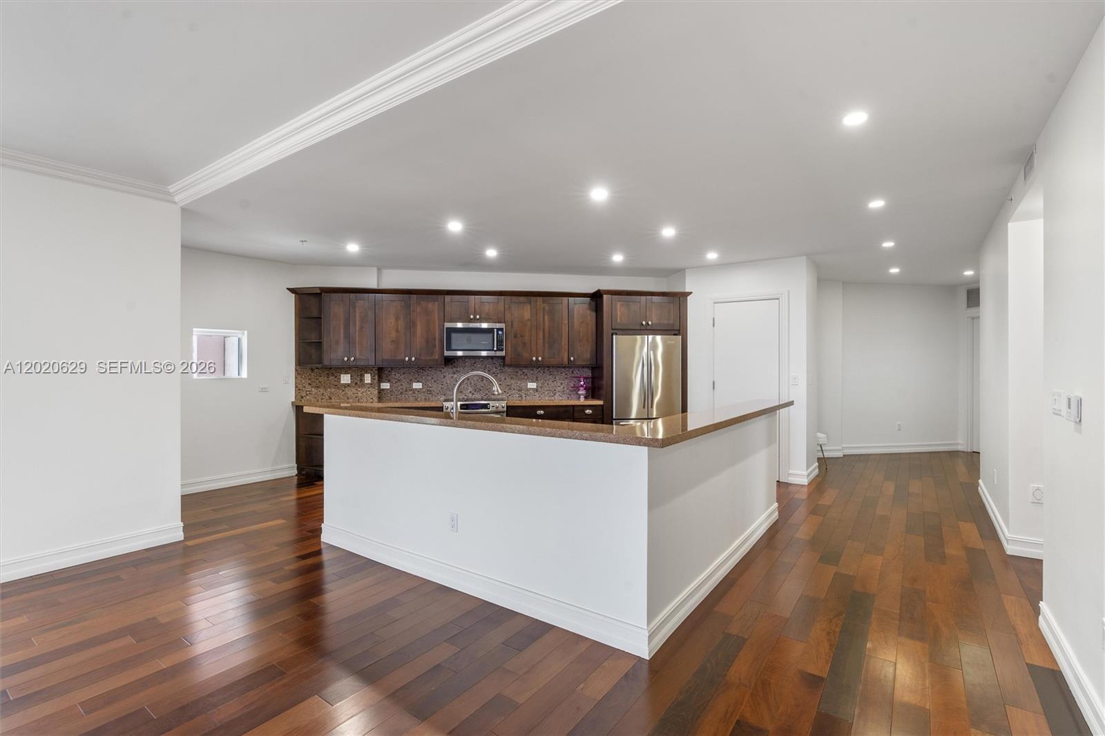 455 East Palmetto Park Road, Unit 4 Boca Raton, FL 33432 - Photo 8 of 30 a large kitchen with stainless steel appliances a large counter top and wooden floors
