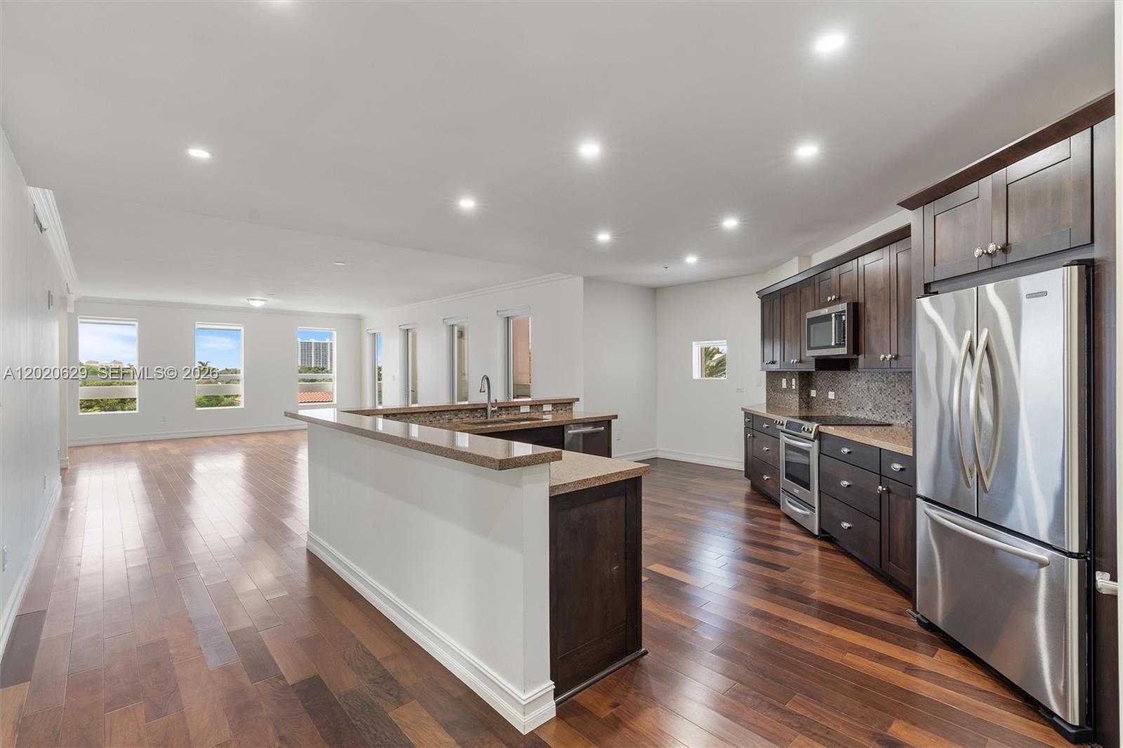 455 East Palmetto Park Road, Unit 4 Boca Raton, FL 33432 - Photo 9 of 30 a kitchen with stainless steel appliances granite countertop a refrigerator a stove oven a sink dishwasher and white countertops with wooden floor