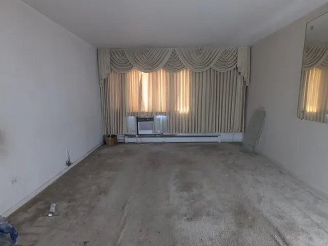 an empty room with a fireplace and windows