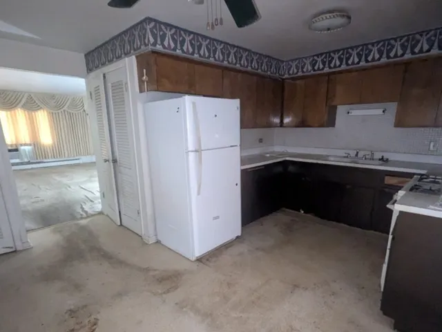 a kitchen with a sink a refrigerator and cabinets