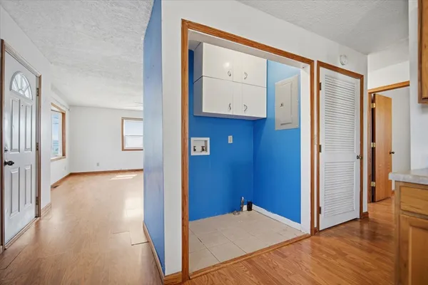a view of a hallway with wooden floor and a kitchen