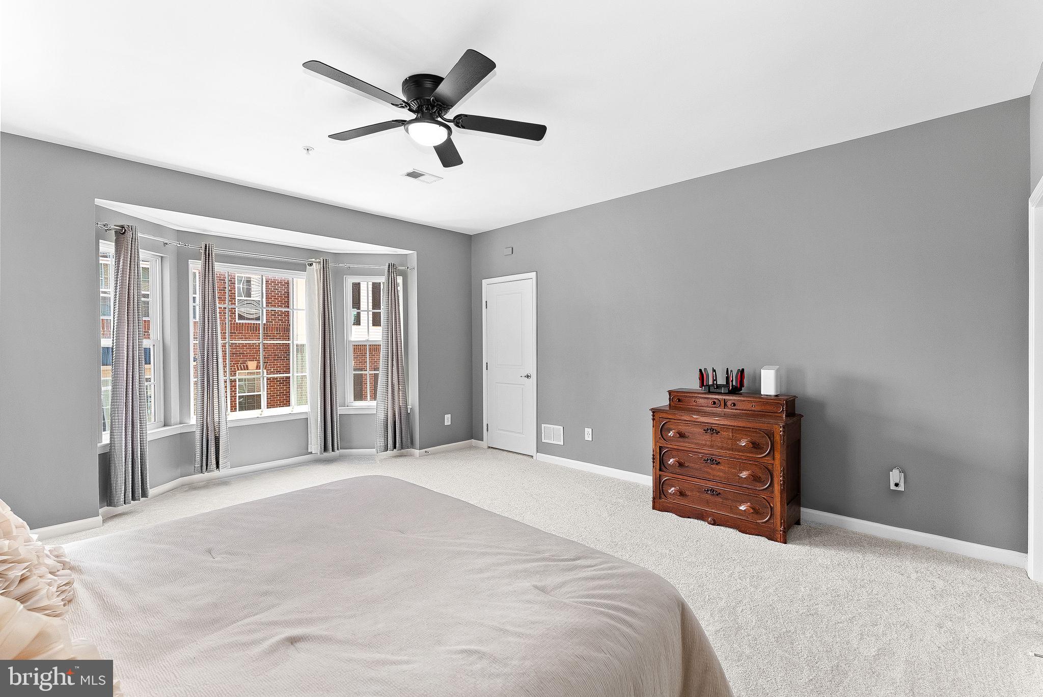 7471 Brunson Circle, Unit 10A Gainesville, VA 20155 - Photo 17 of 30 a bedroom with a bed and a ceiling fan