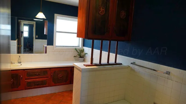 a kitchen with stainless steel appliances granite countertop a sink a stove cabinets and a dining table