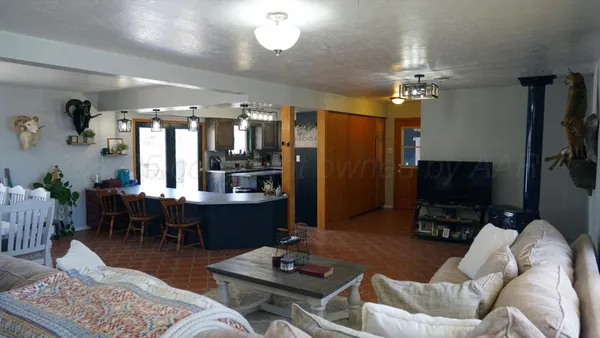 a living room with furniture a chandelier and a flat screen tv