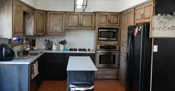 a kitchen with stainless steel appliances a stove a sink and a refrigerator