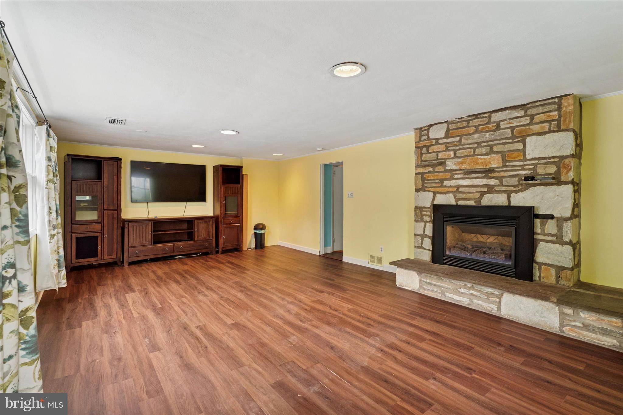 990 Indian Creek Road Jenkintown, PA 19046 - Photo 37 of 58 an empty room with wooden floor fireplace and windows