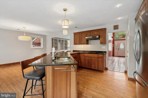 a kitchen with stainless steel appliances granite countertop a sink a stove and a refrigerator