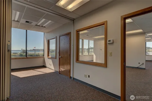 a view of an empty room and a kitchen
