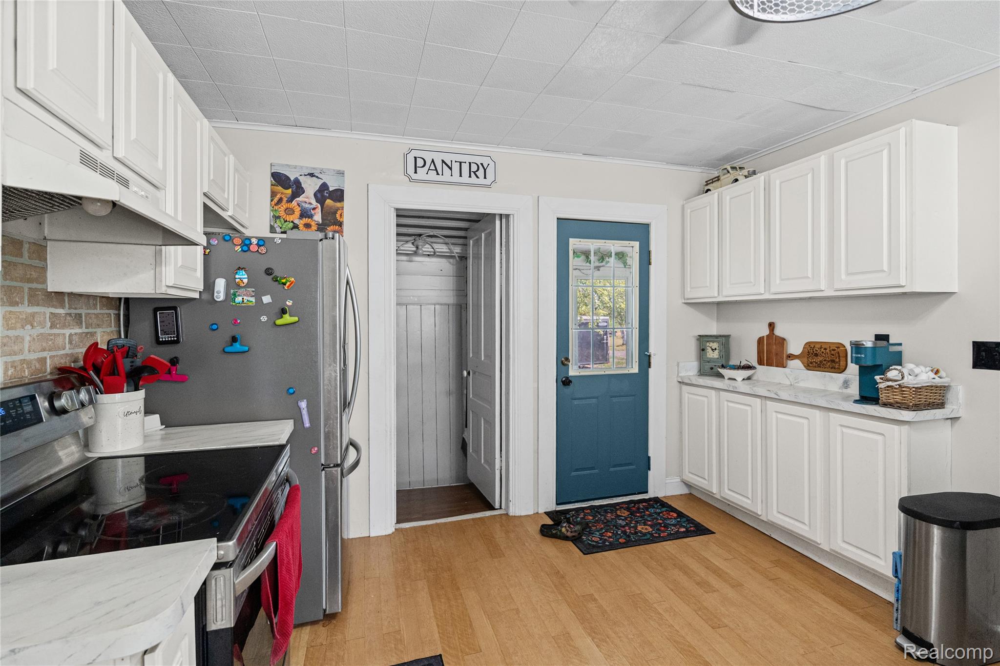 1175 South Morrish Road Flint, MI 48532 - Photo 14 of 72 Kitchen featuring light wood-finish flooring, white cabinetry, light countertops, and a teal door with decorative glass inserts