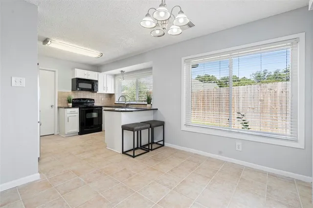a view of an empty room with kitchen microwave and window