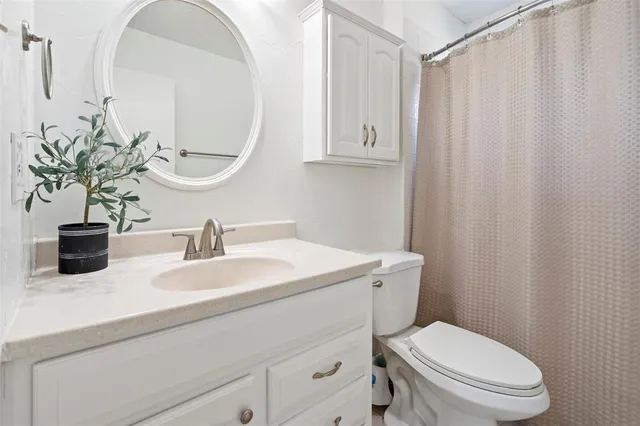 a bathroom with a toilet a sink and mirror