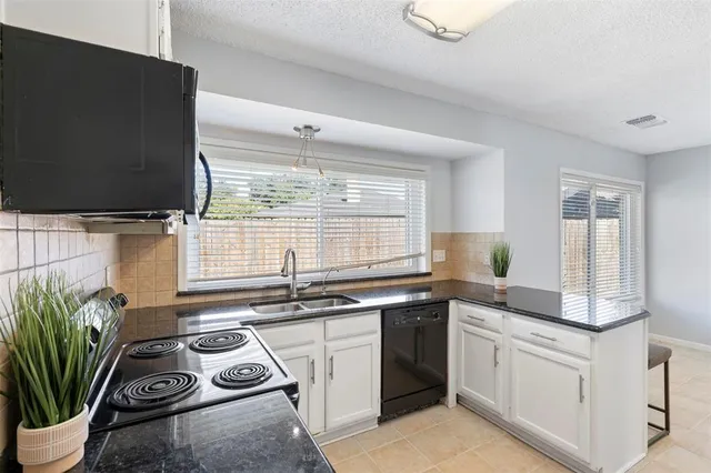 a kitchen with stainless steel appliances a sink stove and cabinets