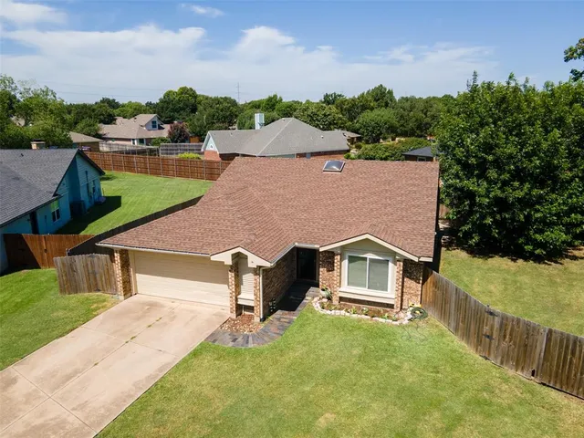 a aerial view of a house next to a yard