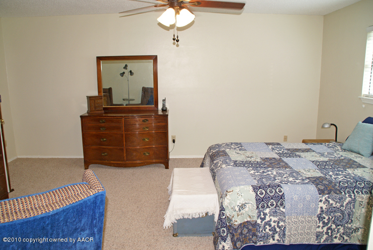 8302 Ranier Drive Amarillo, TX 79110 - Photo 17 of 32 a bedroom with a bed and a dresser