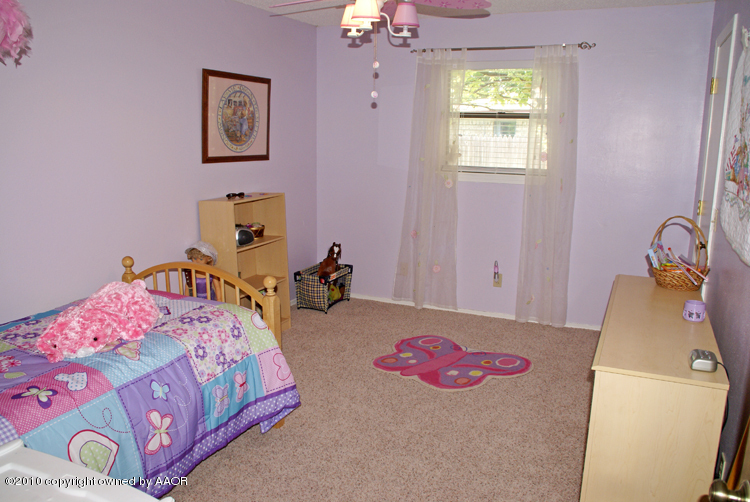 8302 Ranier Drive Amarillo, TX 79110 - Photo 24 of 32 a bedroom with a bed and a chandelier