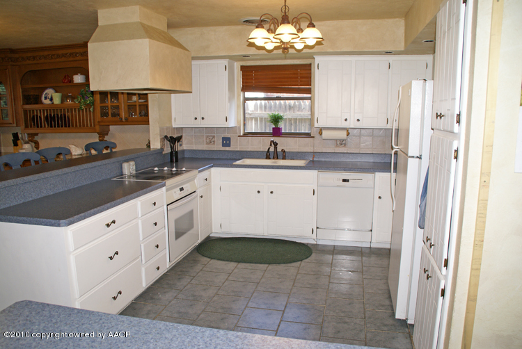 8302 Ranier Drive Amarillo, TX 79110 - Photo 8 of 32 a kitchen with granite countertop a sink stove and cabinets
