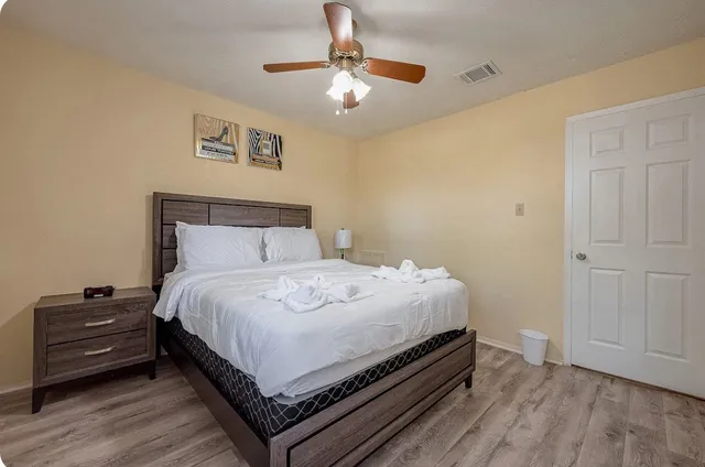 a bedroom with a bed and wooden floor