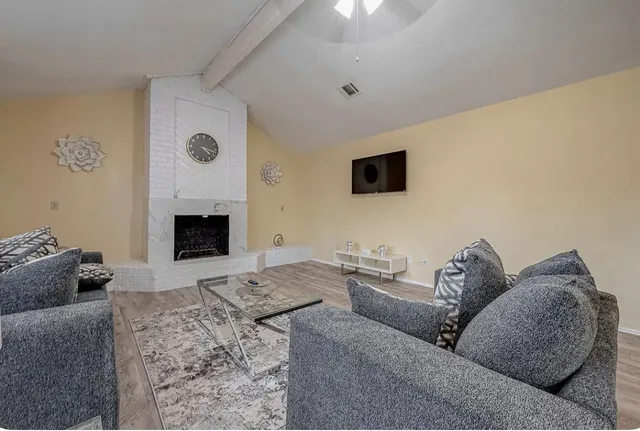 a living room with furniture and a wooden floor