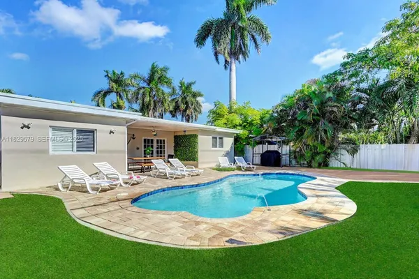 a view of a house with swimming pool and sitting area