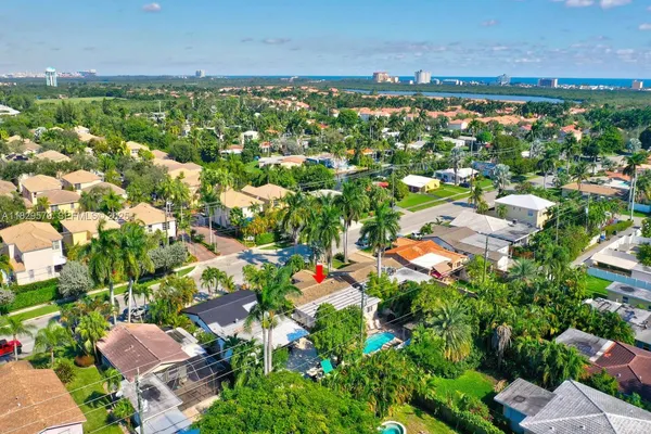 an aerial view of residential houses with outdoor space and trees