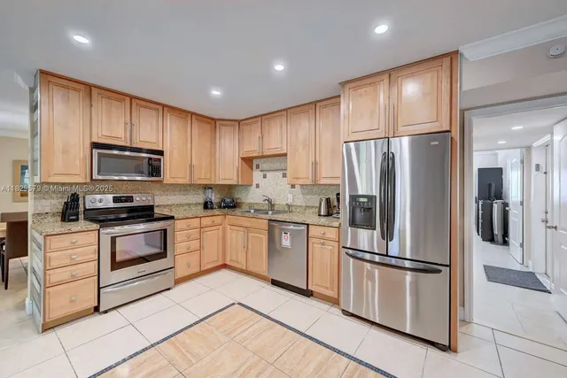 a kitchen with granite countertop white cabinets and stainless steel appliances