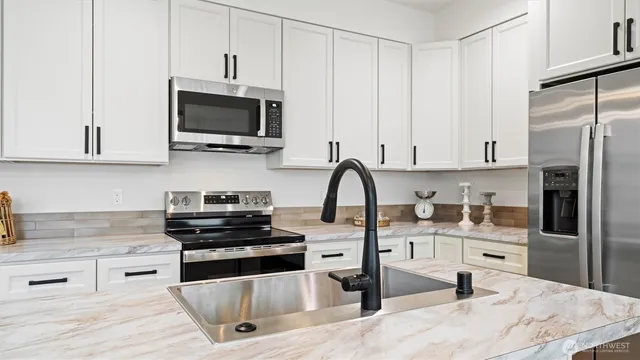 a kitchen with stainless steel appliances granite countertop a refrigerator sink and stove