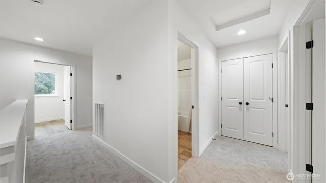 a view of a hallway with closet and bathroom
