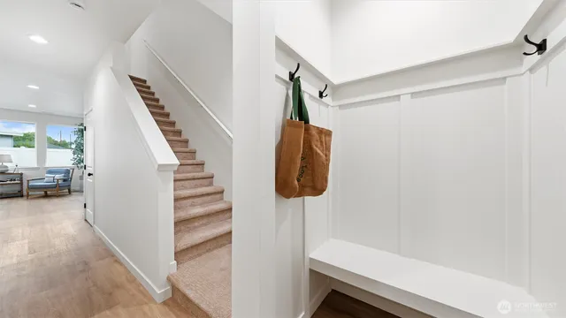 a view of hallway with stairs and wooden floor