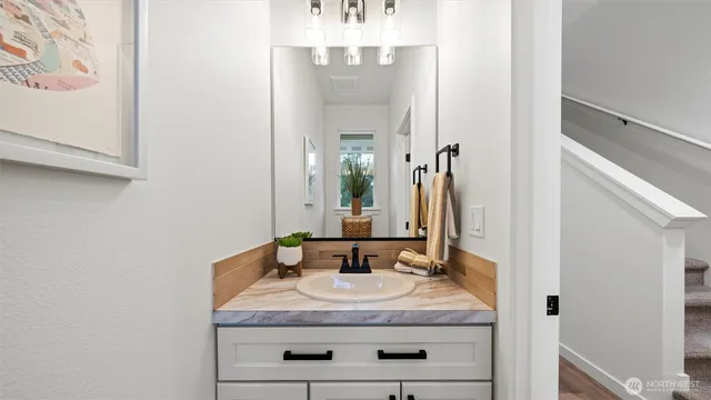 a bathroom with a granite countertop sink and a mirror