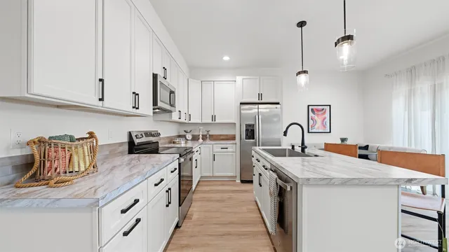 a kitchen with stainless steel appliances granite countertop a sink stove and refrigerator