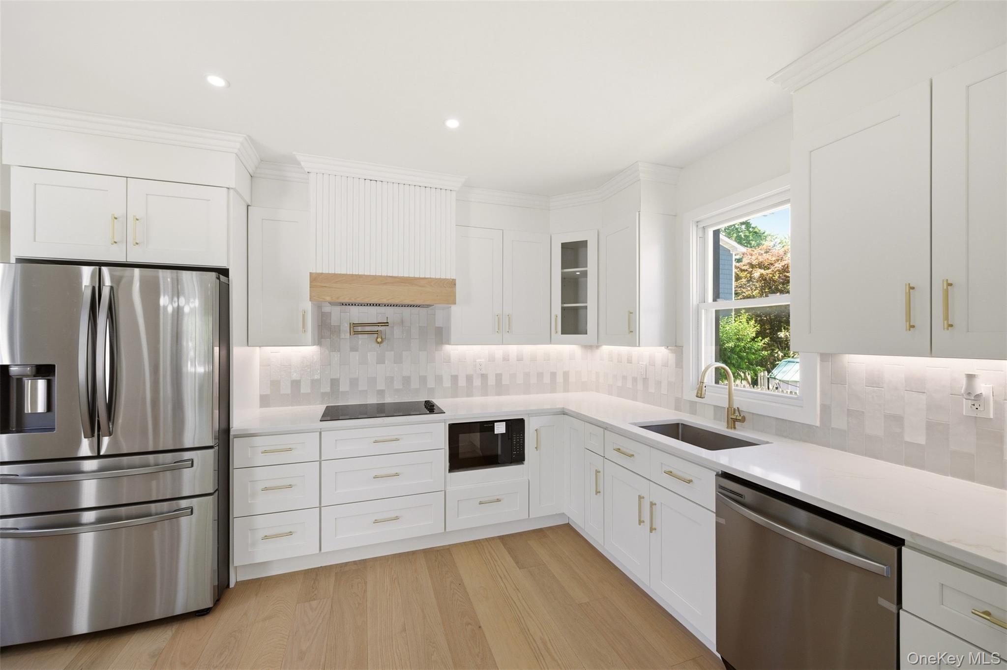 135 Whaley Street Freeport, NY 11520 - Photo 19 of 38 a kitchen with white cabinets and stainless steel appliances