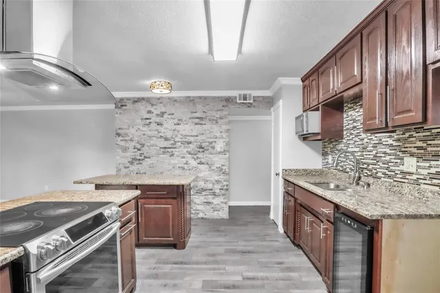 a kitchen with stainless steel appliances granite countertop a sink stove and cabinets