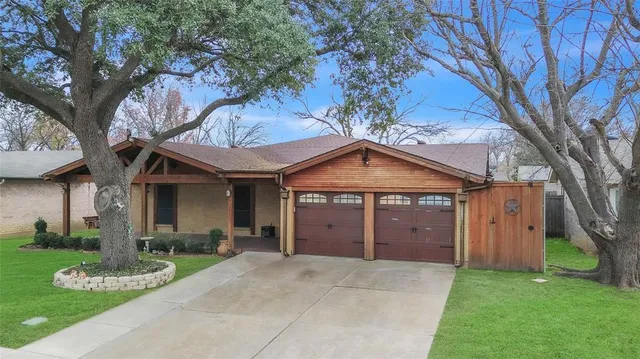 a front view of a house with a garden and yard