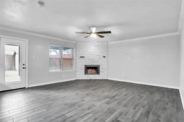 a view of empty room with wooden floor and fireplace