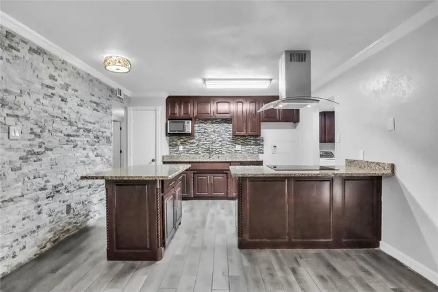 a kitchen with stainless steel appliances granite countertop a sink and wooden floor