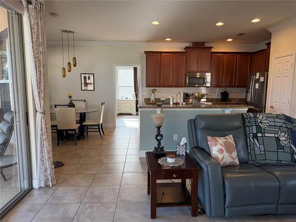a kitchen with a counter top space a sink a flat screen tv and windows