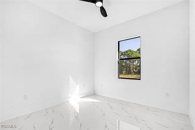 an empty room with a window and ceiling fan