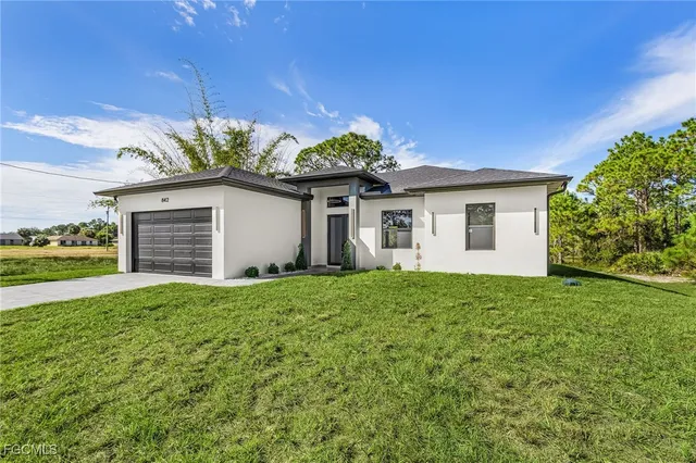 a view of a house with a yard and potted plants