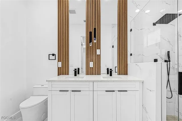 a bathroom with a bathtub sink vanity mirror and toilet