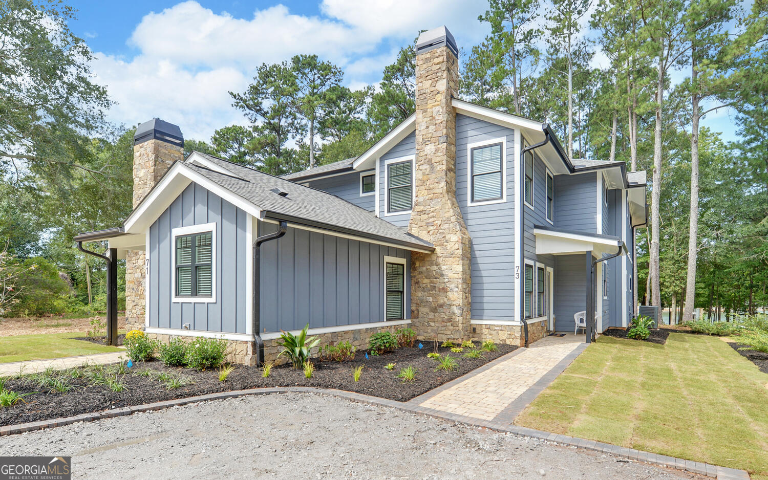 a view of a house with a yard and large tree