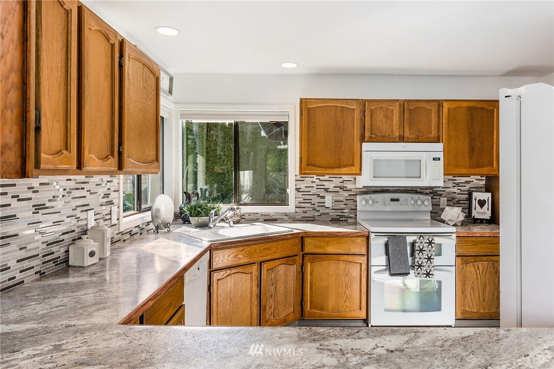 5405 156th Street Southwest Edmonds, WA 98026 - Photo 12 of 27 a kitchen with stainless steel appliances granite countertop a sink stove and cabinets