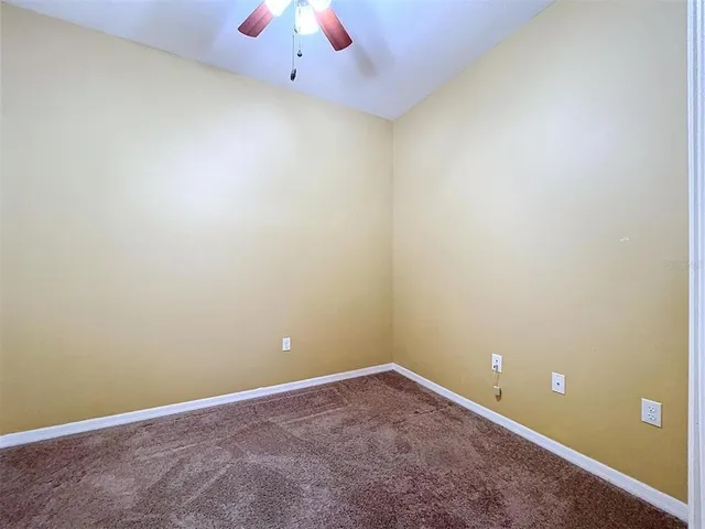 an empty room with a empty space and a ceiling fan