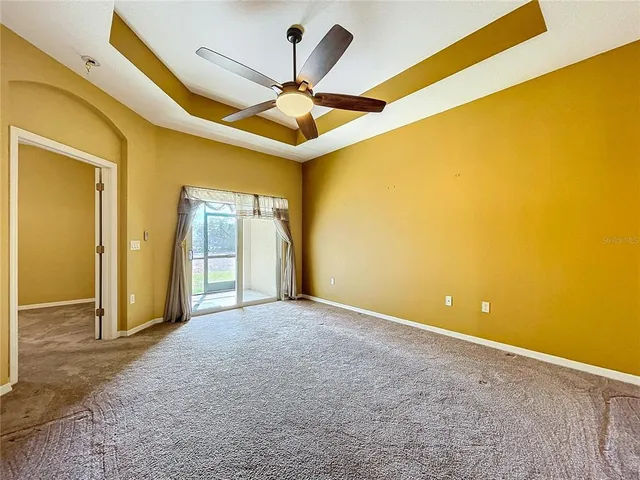 an empty room with a window and a ceiling fan