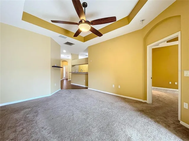 an empty room with a ceiling fan and a window