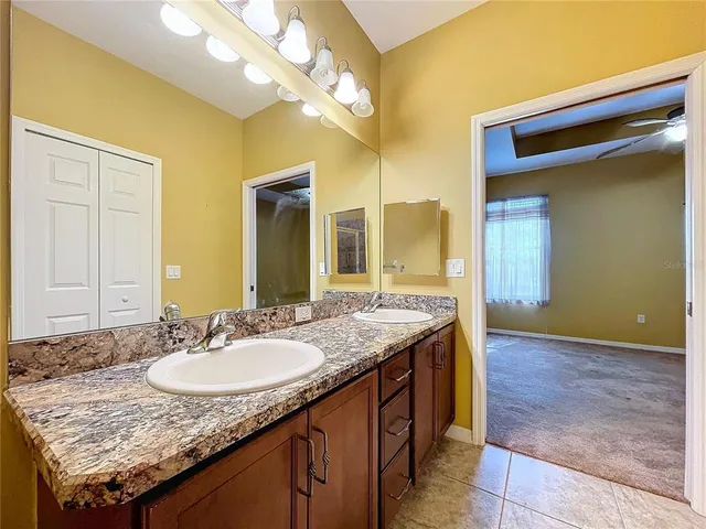 a bathroom with a granite countertop sink a toilet and a mirror