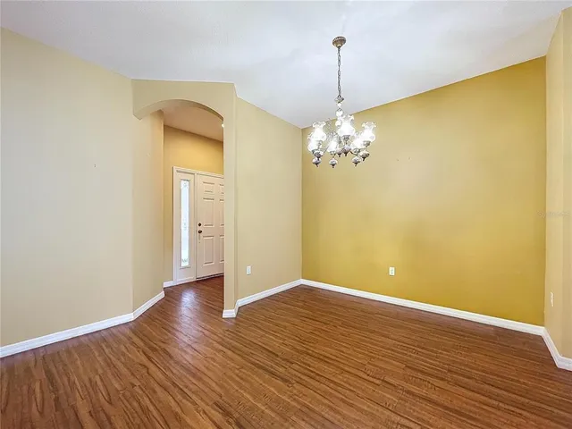 a view of a room with wooden floor and chandelier