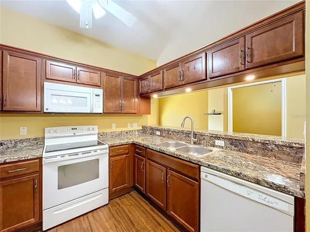 a kitchen with stainless steel appliances granite countertop a sink stove and cabinets
