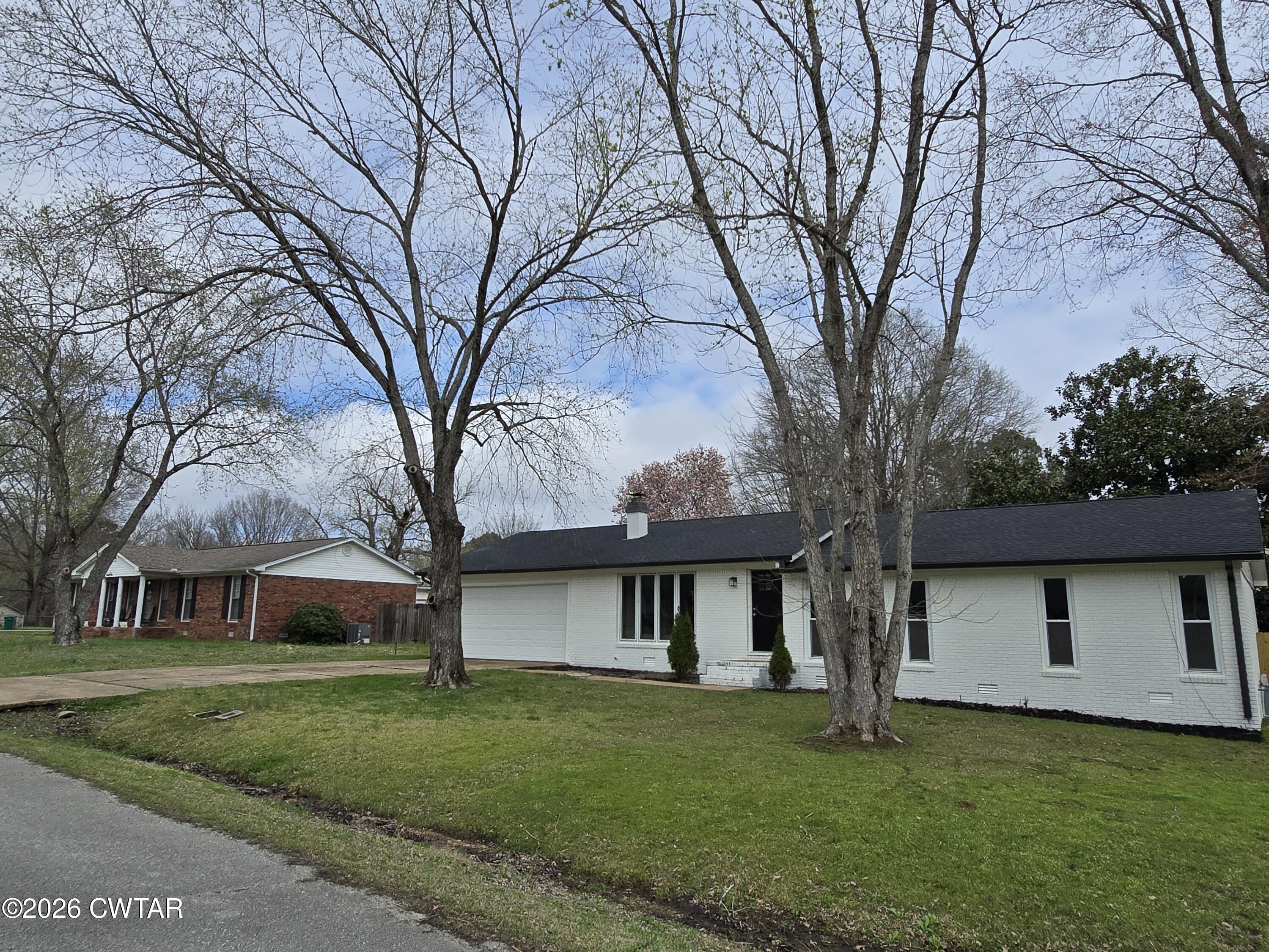 49 Brenda Lane Jackson, TN 38301 - Photo 3 of 23 a front view of a house with a garden and trees