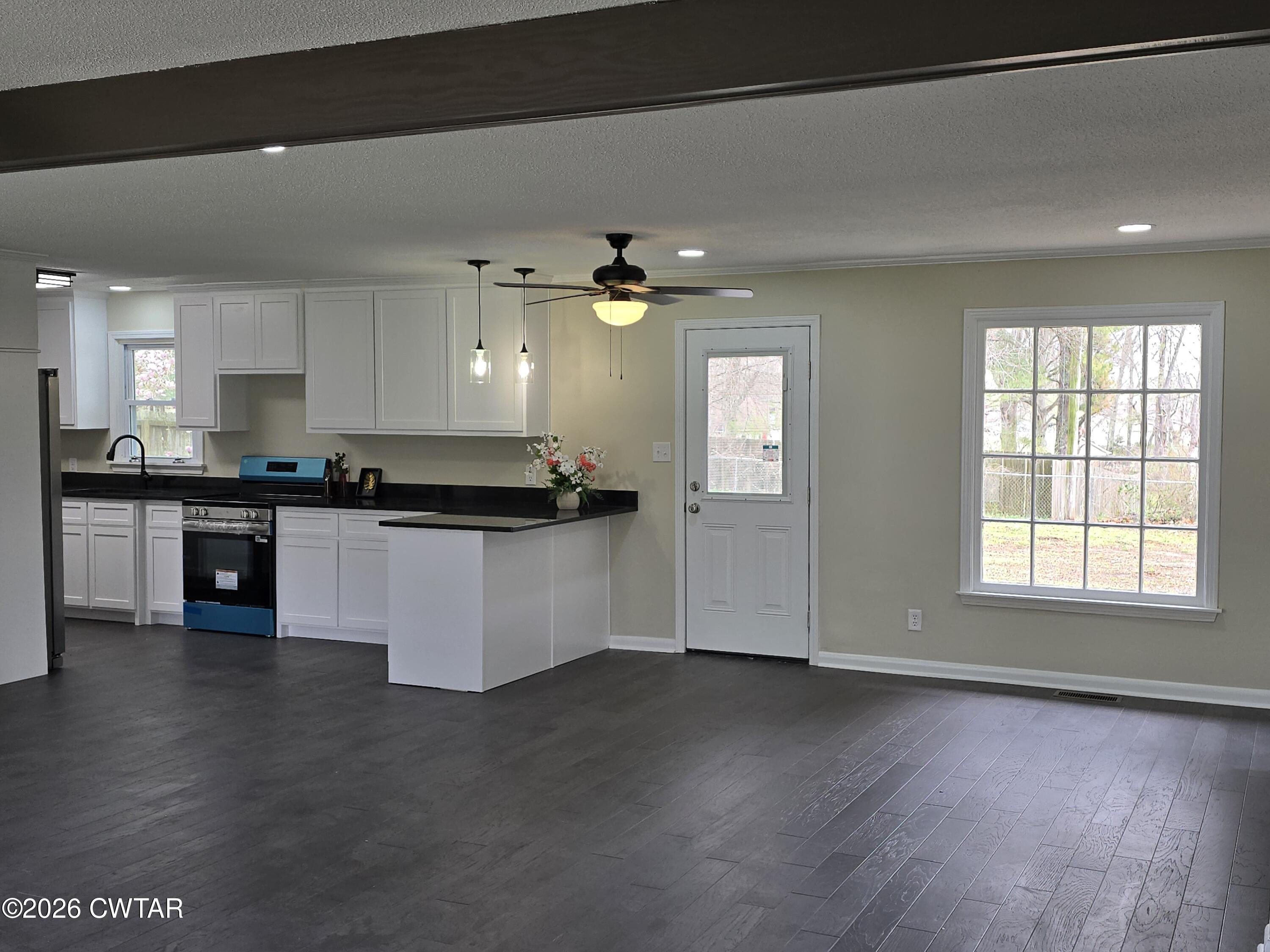 49 Brenda Lane Jackson, TN 38301 - Photo 9 of 23 a kitchen with granite countertop a stove top oven a sink and white cabinets with wooden floor